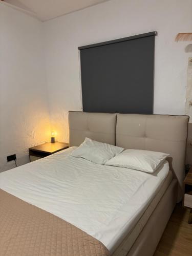 a bed with white sheets and a black headboard at Little paradise in Limassol