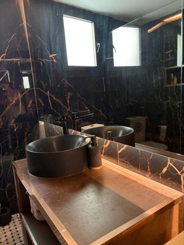 a bathroom with two sinks and two mirrors at Little paradise in Limassol