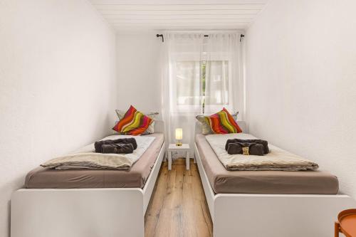 two beds in a room with white walls and wooden floors at MOLA Apartments - Panoramablick, Balkon, 5 Pers, Bahnhofsnähe, Parkplatz in Herdecke
