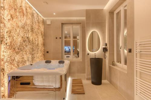 a bathroom with a sink and a mirror at Suite Prestige Spa Privatif D'exception in LʼIsle-Adam