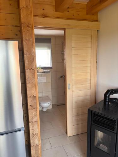 a kitchen with a refrigerator and a toilet in it at Apartman Andrej in Kolarec