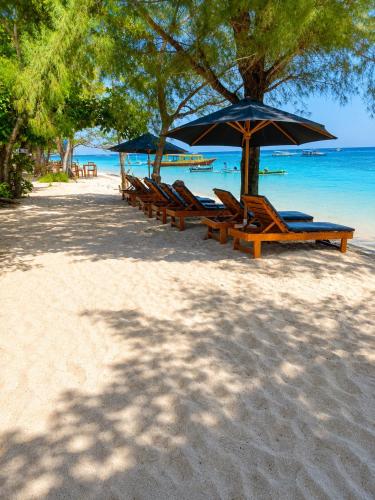 a group of chairs and umbrellas on a beach at Villa Samalas Boutique Resort & Private Pool Villas in Gili Meno