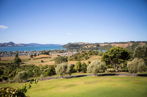 a view of a park with trees and a body of water at Mercury Ridge in Cooks Beach