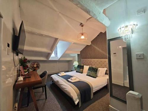a hotel room with a bed and a desk and a mirror at The Old Stamp House Retreat - Three En-suite Bedrooms with Parking in Ambleside