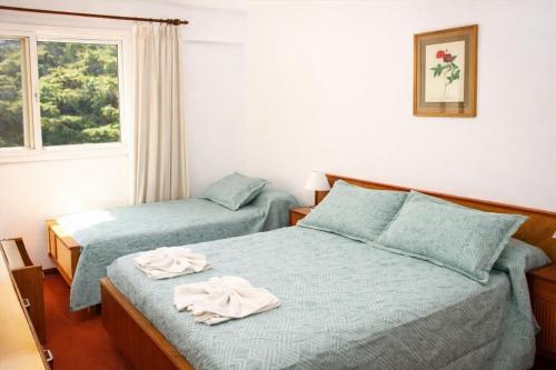 two beds in a bedroom with towels on them at Gran Hotel Nortomarza in La Falda