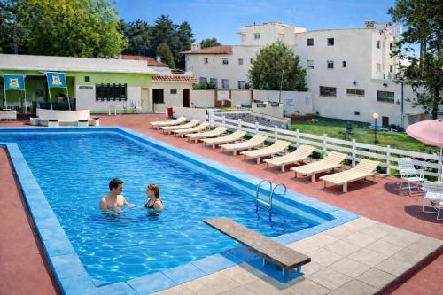 a man and a woman are in a swimming pool at Gran Hotel Nortomarza in La Falda