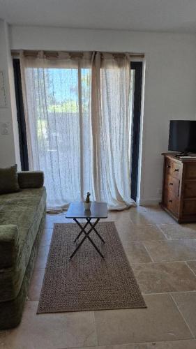 a living room with a couch and a table in front of a window at Partie de ferme appartement in Paluds de Noves