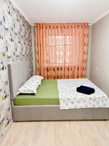 a small bedroom with a bed with a window at Квартира Иртыш in Pavlodar