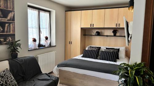 a bedroom with a bed and a chair and a window at La Casina - Centro Colere - 600mt dagli impianti in Colere