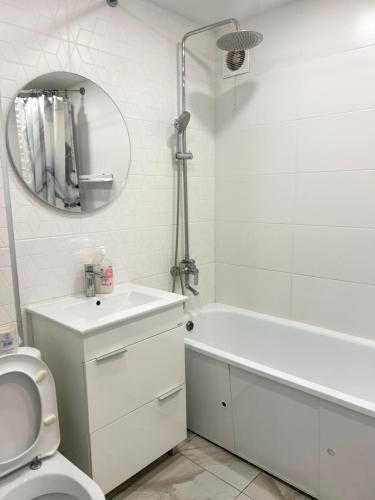 a bathroom with a toilet and a sink and a mirror at Квартира Иртыш in Pavlodar