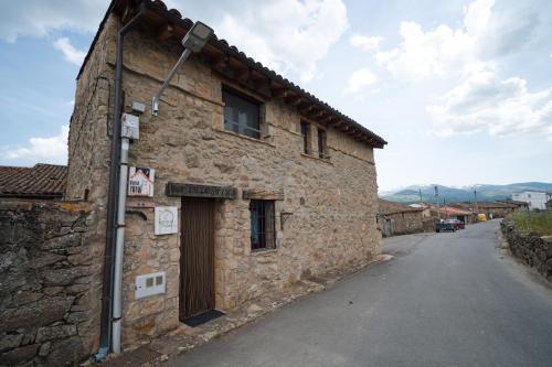 an old stone building on the side of a street at Casa Rural La Celestina in Navalmoro