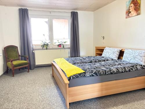 a bedroom with a bed and a chair and a window at Ferienwohnung im Ort in Röbel