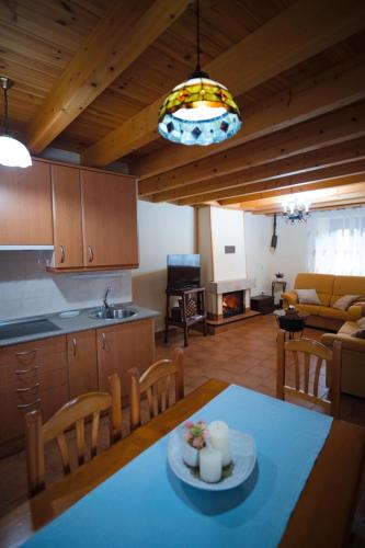 a kitchen and a living room with a table and chairs at Casa Rural La Celestina in Navalmoro