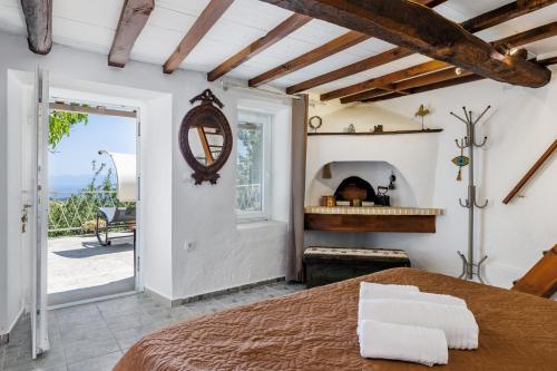 a bedroom with a bed and a view of the ocean at Pyrgos Country House in Skopelos Town