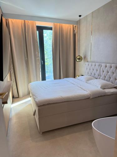 a bedroom with a large bed and a large window at Apartament - VIDOK 110 in Olsztyn