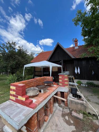 a brick barbecue grill in front of a house at Ordinacija pod šljivom in Pirot