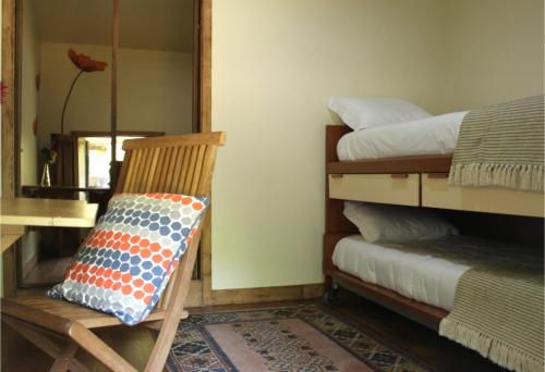 a chair with a pillow on it in a room at Casa Moinho da Levada - Refúgio à beira do rio Coura in Paredes de Coura