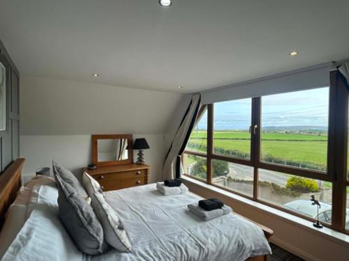 a bedroom with a bed and a large window at Valleyview House in Thurso