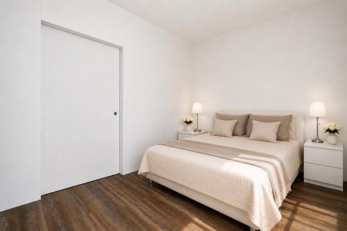 a white bedroom with a bed and two lamps at ALURE RESIDENCES 1 & 24h self check-in, free parking in front of the apartment building, new building, terrace, cafe with breakfast in the apartment building, next to the aqua park in Banská Bystrica