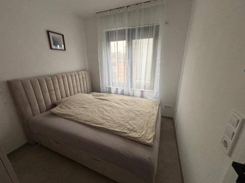 a small bed in a room with a window at Ferienwohnung Mina in Münsingen