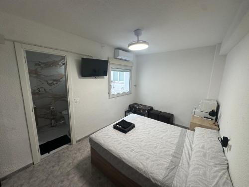 a bedroom with a bed and a window and a mirror at TAJ ROOM center altea #D in Altea