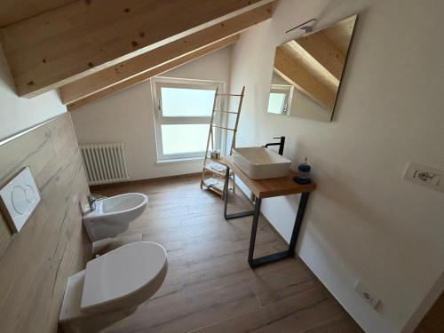a bathroom with two toilets and a sink and a mirror at Dalla zia Gemma in Carano