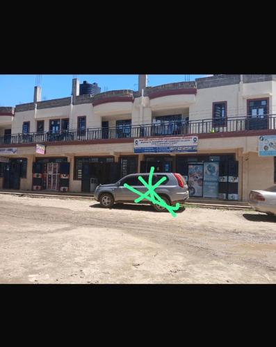 a car parked in front of a building with a green star at Lucky House Studio in Nanyuki