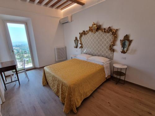 a bedroom with a bed and a large window at Albergo Il Marzocco - Hotel dal 1860 in Montepulciano