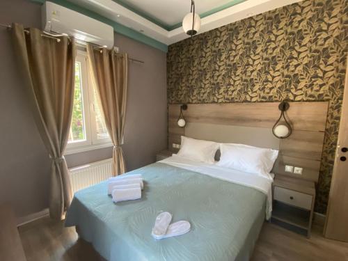 a bedroom with a bed with two slippers on it at Anaxos Garden in Anaxos