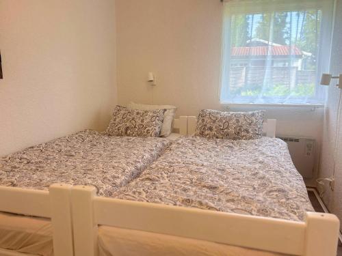 a white bed in a room with a window at Schwedenhaus am See in Storfors