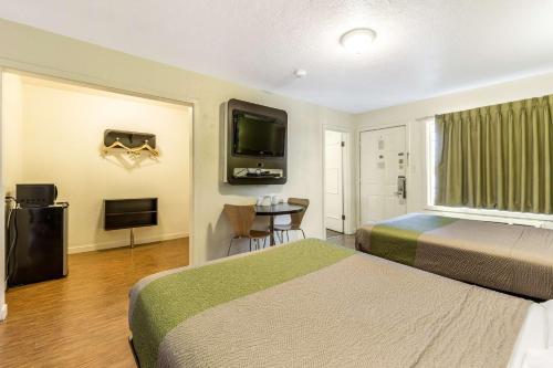 a hotel room with two beds and a flat screen tv at Motel 6 San Rafael in San Rafael