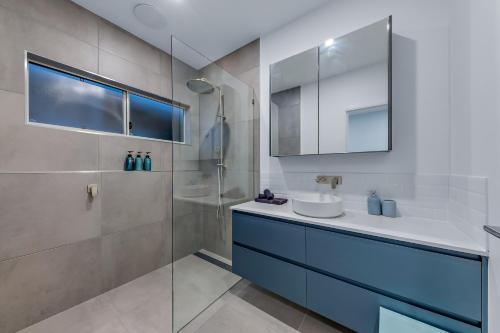 a bathroom with a sink and a shower at Seabreeze Lookout Azul in Airlie Beach
