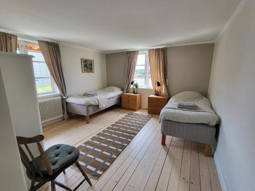 a small bedroom with two beds and a chair at Smedstugan in Norrköping