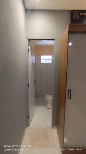 a bathroom with a toilet and a door open at Casa Toda com Garagem a 3km do Aeroporto in Teresina