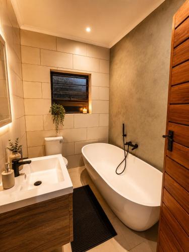 a bathroom with a white tub and a sink at Lloyds - 6 in Ermelo
