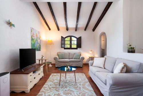 ein Wohnzimmer mit Sofa und Fernseher in der Unterkunft Monte Borboleta - Villas, Apartments in Faro