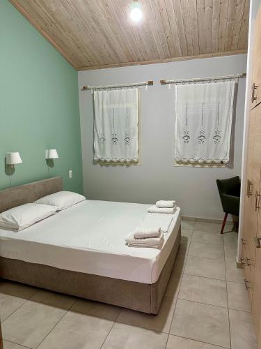 a bedroom with a large bed with white sheets at Glikis Ear Apartments in Gliki
