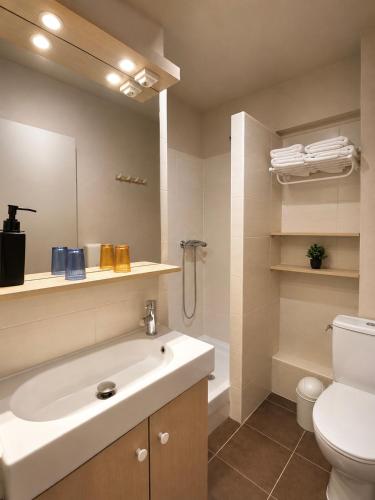 a bathroom with a white sink and a toilet at Hôtel Le Chastellan in Valberg