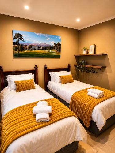 a bedroom with two beds with towels on them at Lloyds - 6 in Ermelo