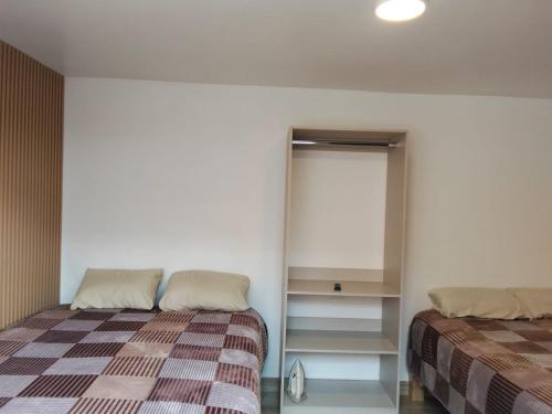 a bedroom with a bed and a closet with a window at Suite La Frontera in Tulcán