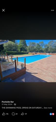 a picture of a swimming pool with benches in front at Chalet 85 in Caeathro
