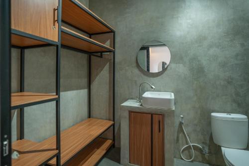 a bathroom with a sink and a toilet and a mirror at Villa Dake Tanah Lot in Tanah Lot
