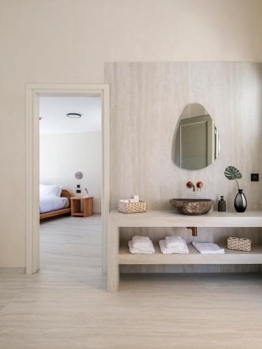 a bathroom with a sink and a mirror at Vinara Luxury Suites Mykonos in Mykonos
