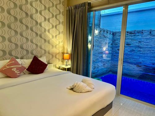 a bedroom with two beds and a large window at ChinJu PoolVilla in Jomtien Beach