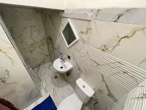 a white bathroom with a sink and a toilet at Maison-Lala Takerkoust et agafay in Lalla Takerkoust