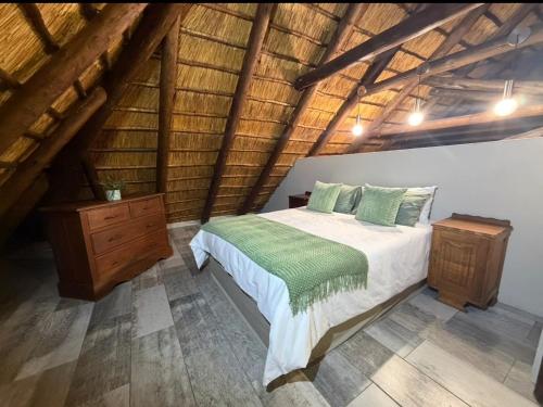 a bedroom with a bed and a wooden ceiling at La Bella Vita Marloth Park in Marloth Park