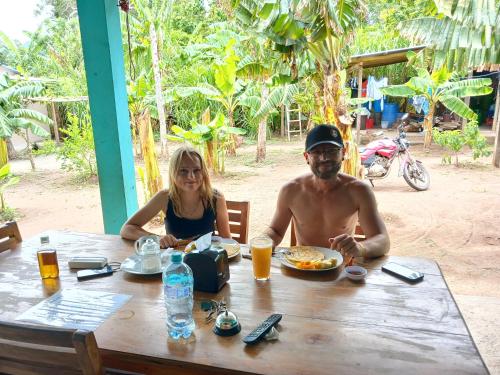 a man and woman sitting at a table with a plate of food at Sunny Garden Lodge in Mérida