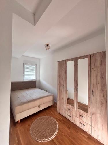 a bedroom with a bed and a wooden wall at Apartman ART Foca in Foča