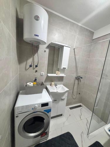 a bathroom with a washing machine and a sink at Apartman ART Foca in Foča