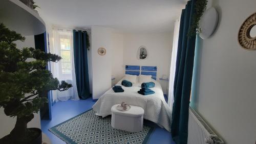 a blue and white bedroom with a bed and blue floors at Auberge du fromager in Saint-Didier-sur-Doulon